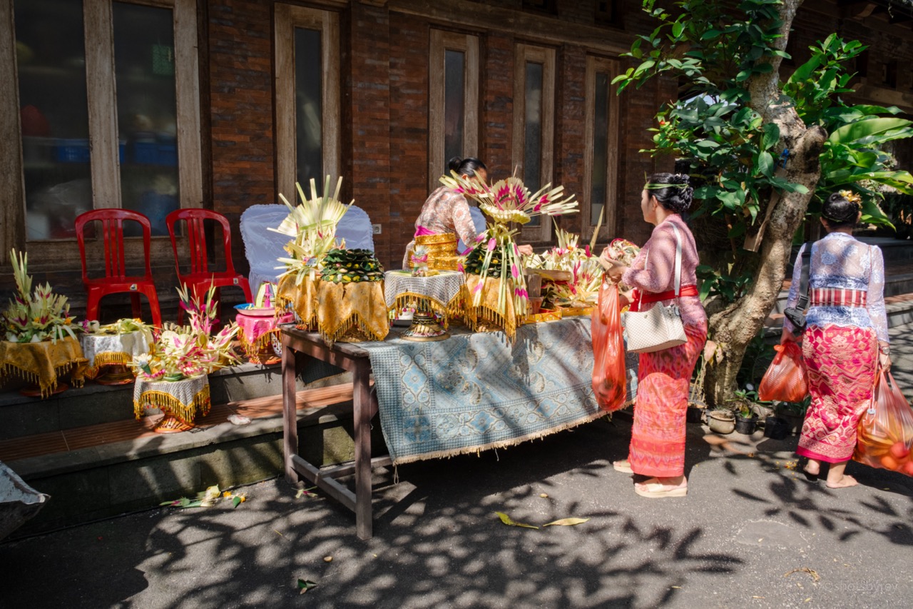 Close up of intricate Balinese wood carving and offerings